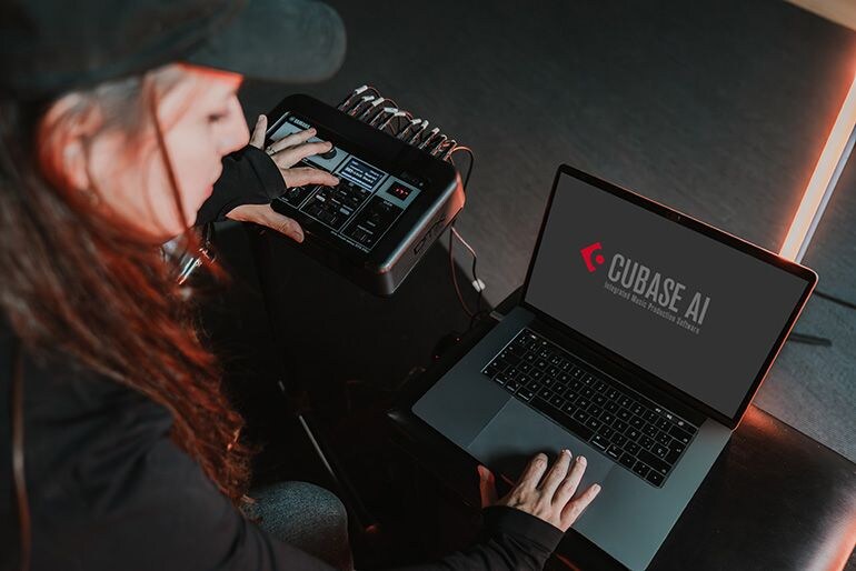 A woman adjusting an electronic drum module and a PC