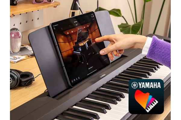 The Yamaha “Smart Pianist” app icon, together with a tablet placed on the music stand of the P-143